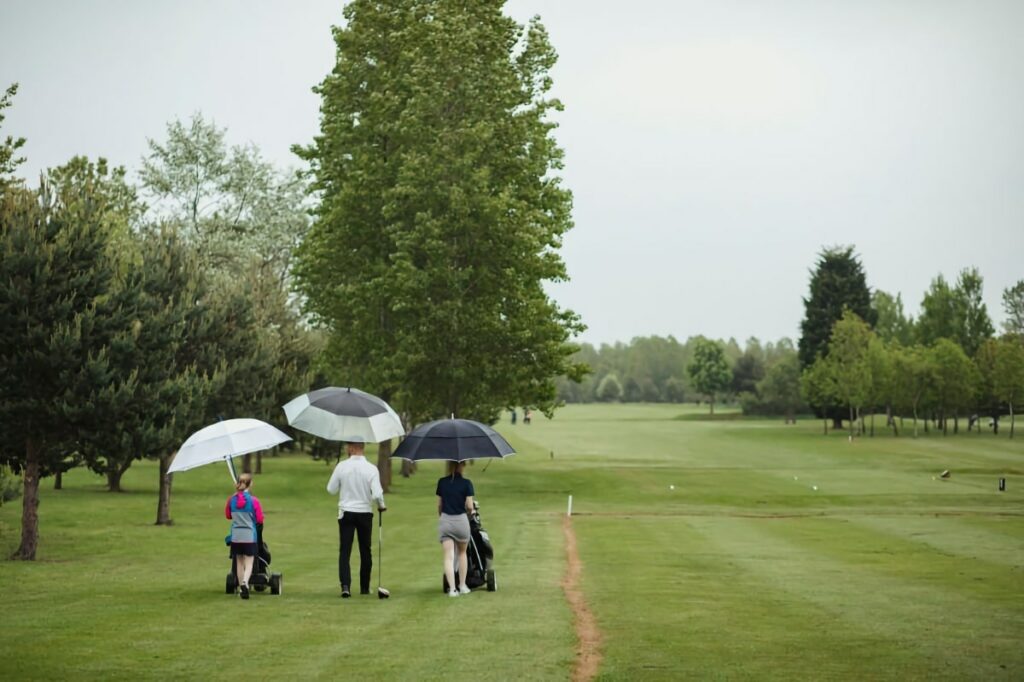 golfers on the course in the rain